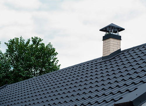 A black roof topped with a chimney, highlighting hurricane-proofing measures for homes in the Rio Grande Valley.