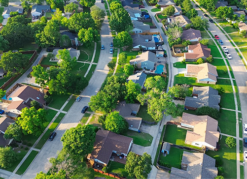 Aerial view of a suburban neighborhood showcasing homes, streets, and greenery, highlighting McAllen's charm and community.