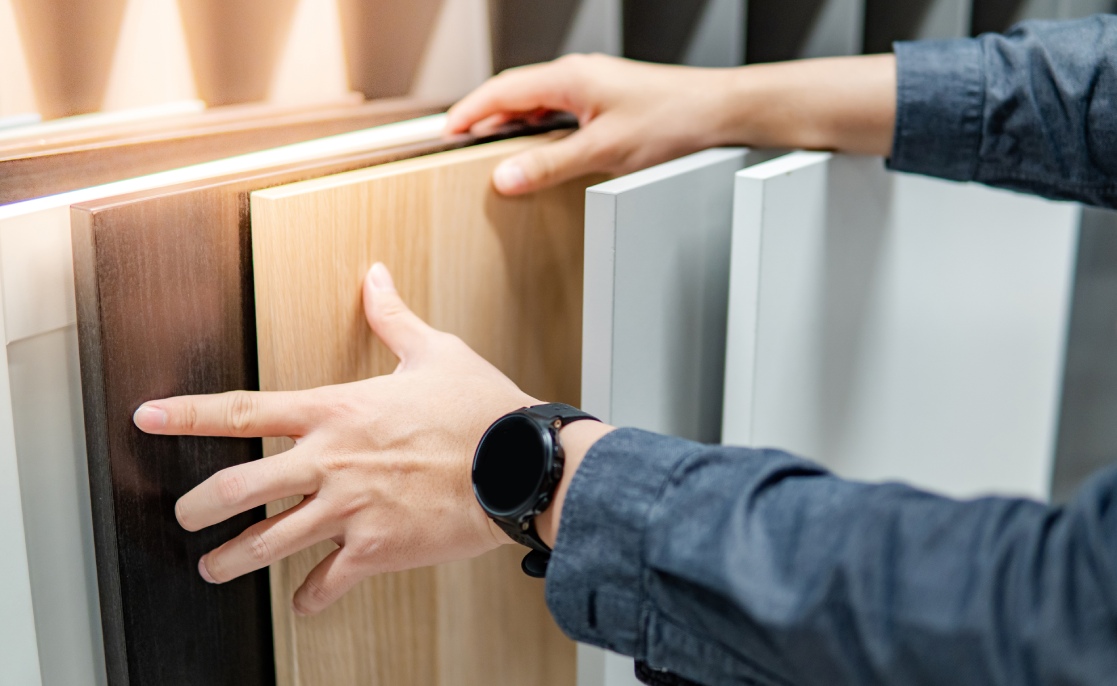 Male hand choosing cabinet panel materials or countertops for built-in furniture design. Shopping furniture and decoration. Home improvement concept