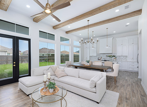 A cozy living room featuring a ceiling fan and exposed wooden beams, showcasing modern home remodeling ideas in Texas.