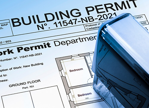 Close-up of a hand holding a building permit, representing the initial step in constructing a custom home in Brownsville, TX.