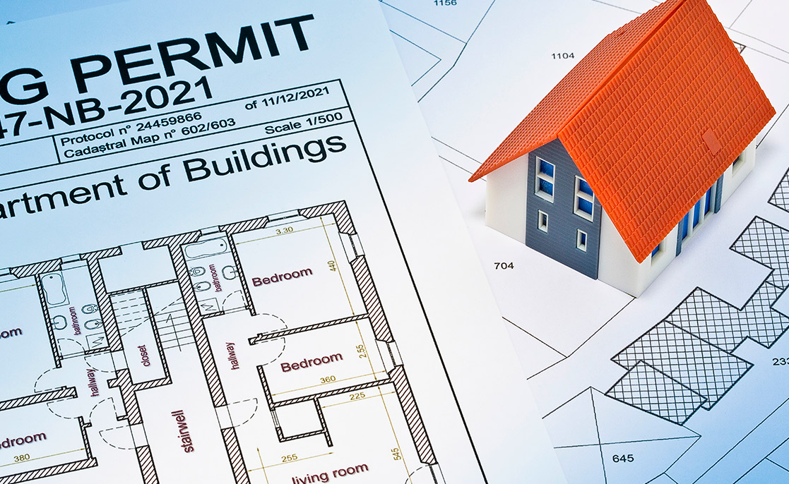 A building permit in focus, representing the steps to purchase land or initiate home construction.