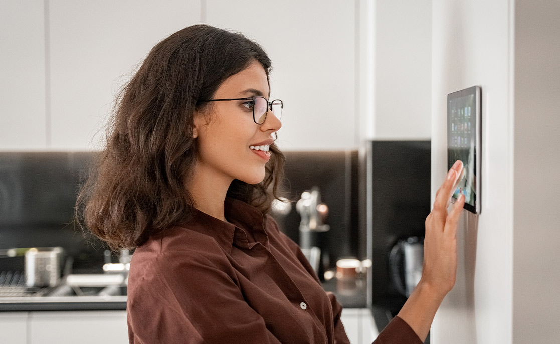 A woman in glasses touches a digital screen, highlighting desired features in new homes for buyers in McAllen and Harlingen.