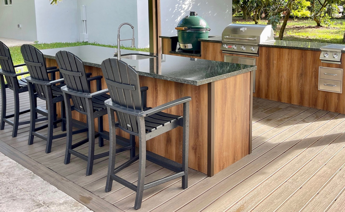 Stylish outdoor kitchen with bar stools and a grill, showcasing popular amenities for new home buyers in McAllen and Harlingen.